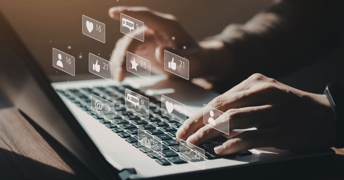 Person typing on a computer with a bunch of social media icons around it